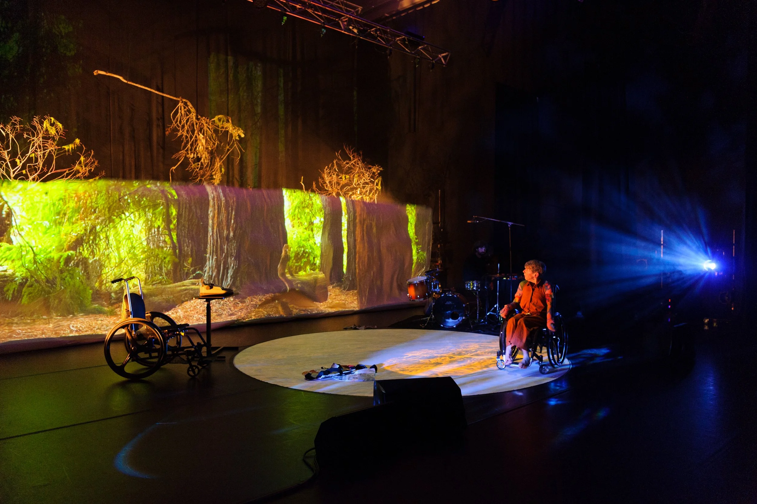 Melinda Smith sul palco di Conduit Bodies, davanti a una proiezione ambientale.